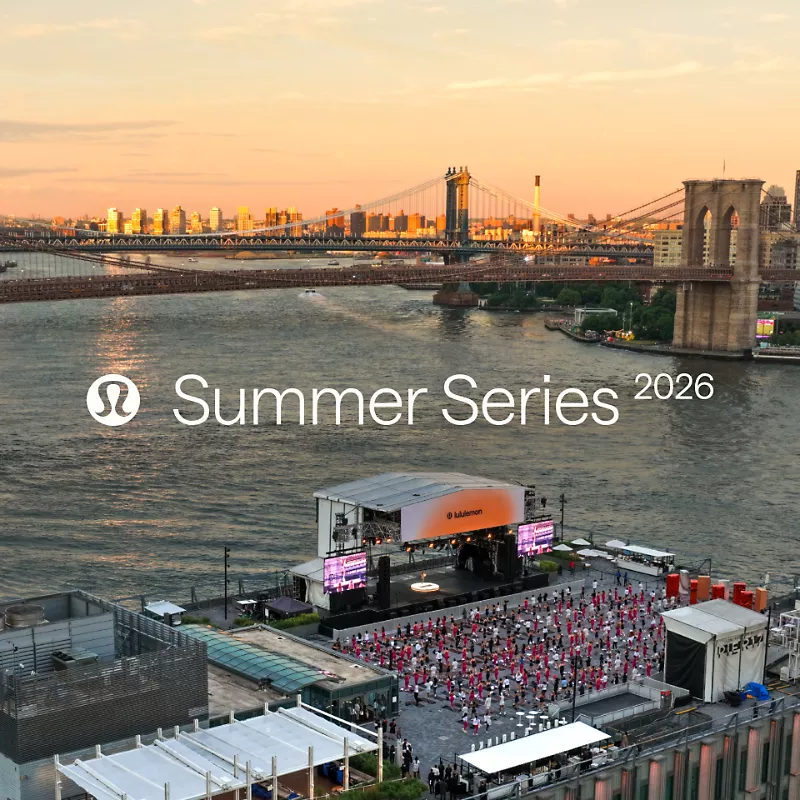 A large group takes a Pilates class on a rooftop at sunset with the Brooklyn Bridge and New York City skyline in the background. A text overlay reads: "lululemon Summer Series 2026"